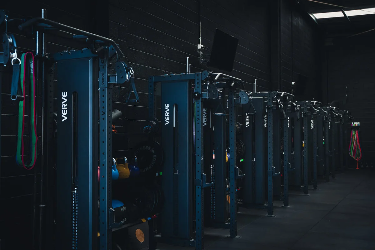 A row of VERVE functional trainers inside a dark commercial gym